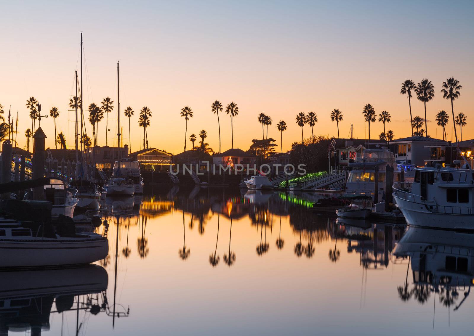 Sunset over residential development by water in Ventura California with modern homes and yachts boats