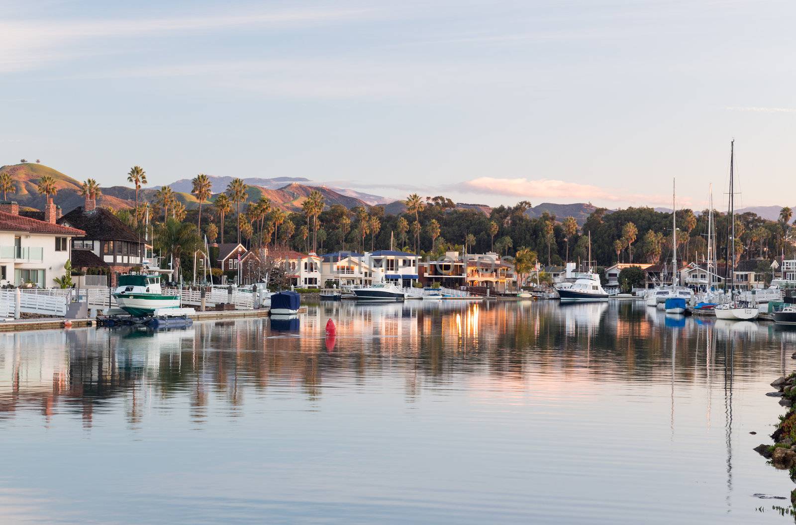 Sunrise at residential development by water in Ventura California with modern homes and yachts boats
