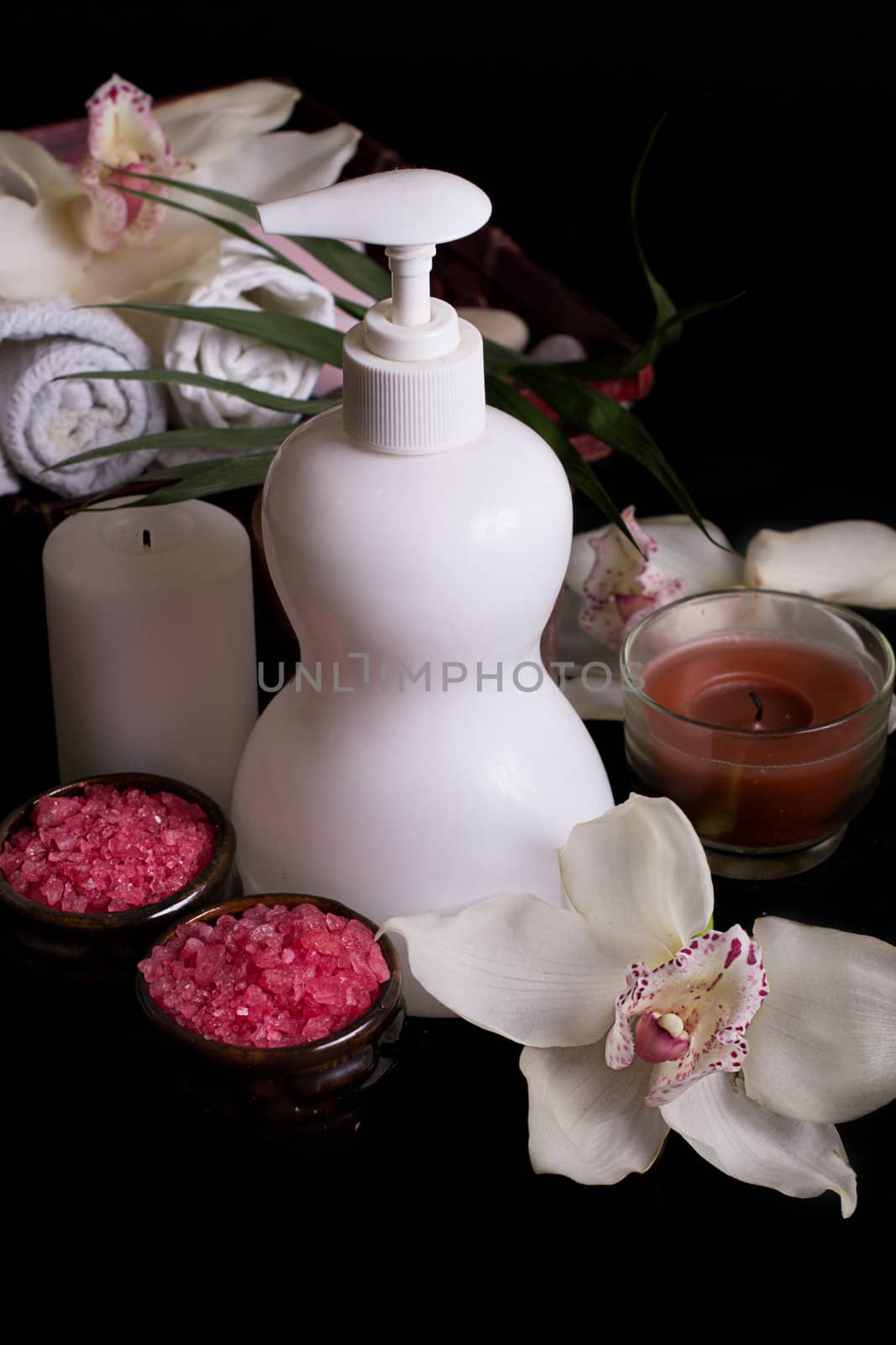 White orchids and spa treatment products isolated on black