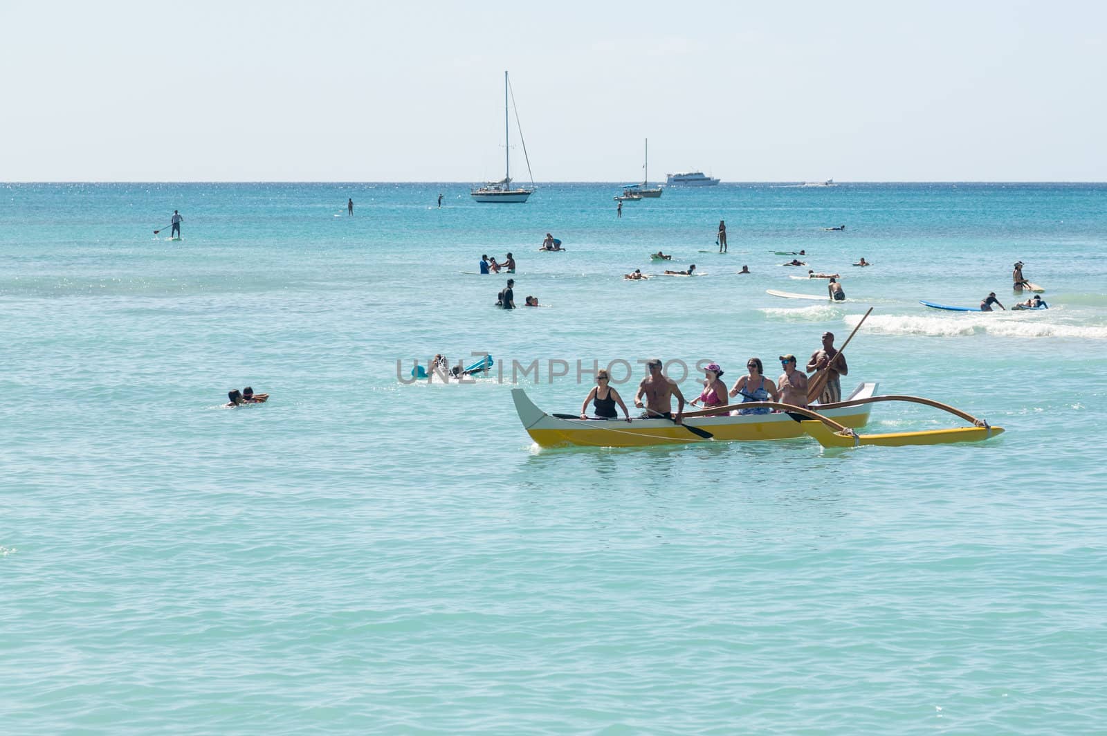 WAIKIKI, HI - JANUARY 20: Tourists in traditional Hawaiian canoe make for shore on 20 January 2012. A Waikiki Beach restoration project was completed early 2012.