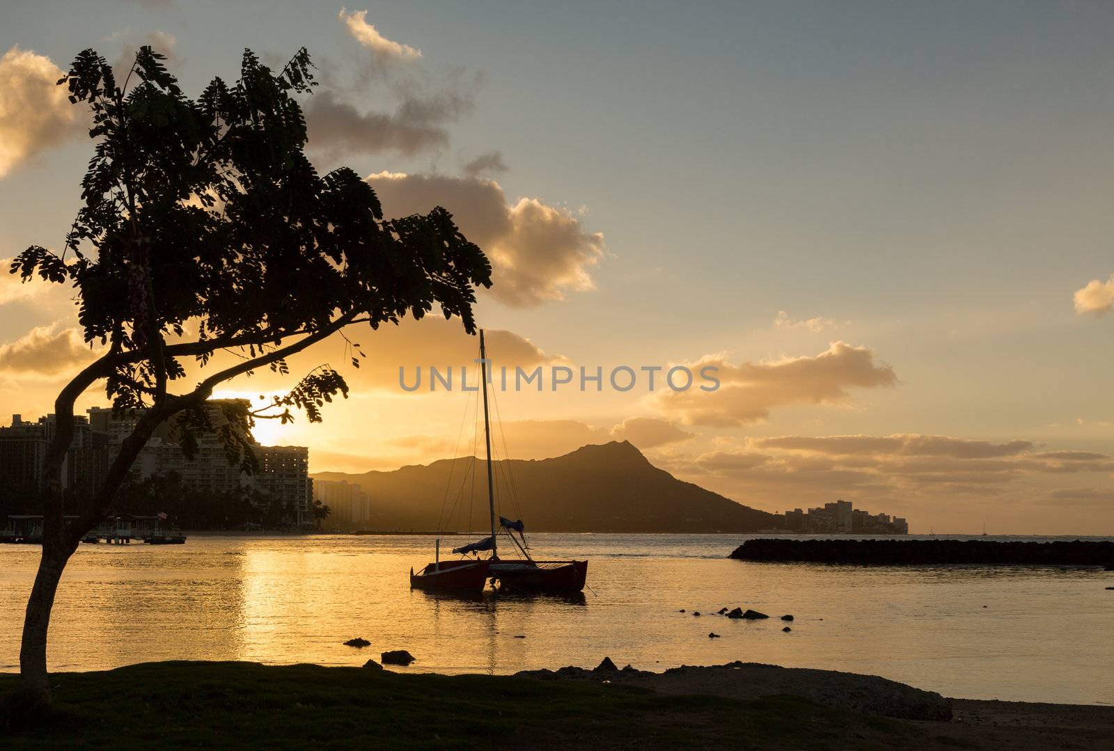 Early morning sunrise at dawn illuminates clouds over Diamond Head and Waikiki Beach area of Oahu in Hawaii