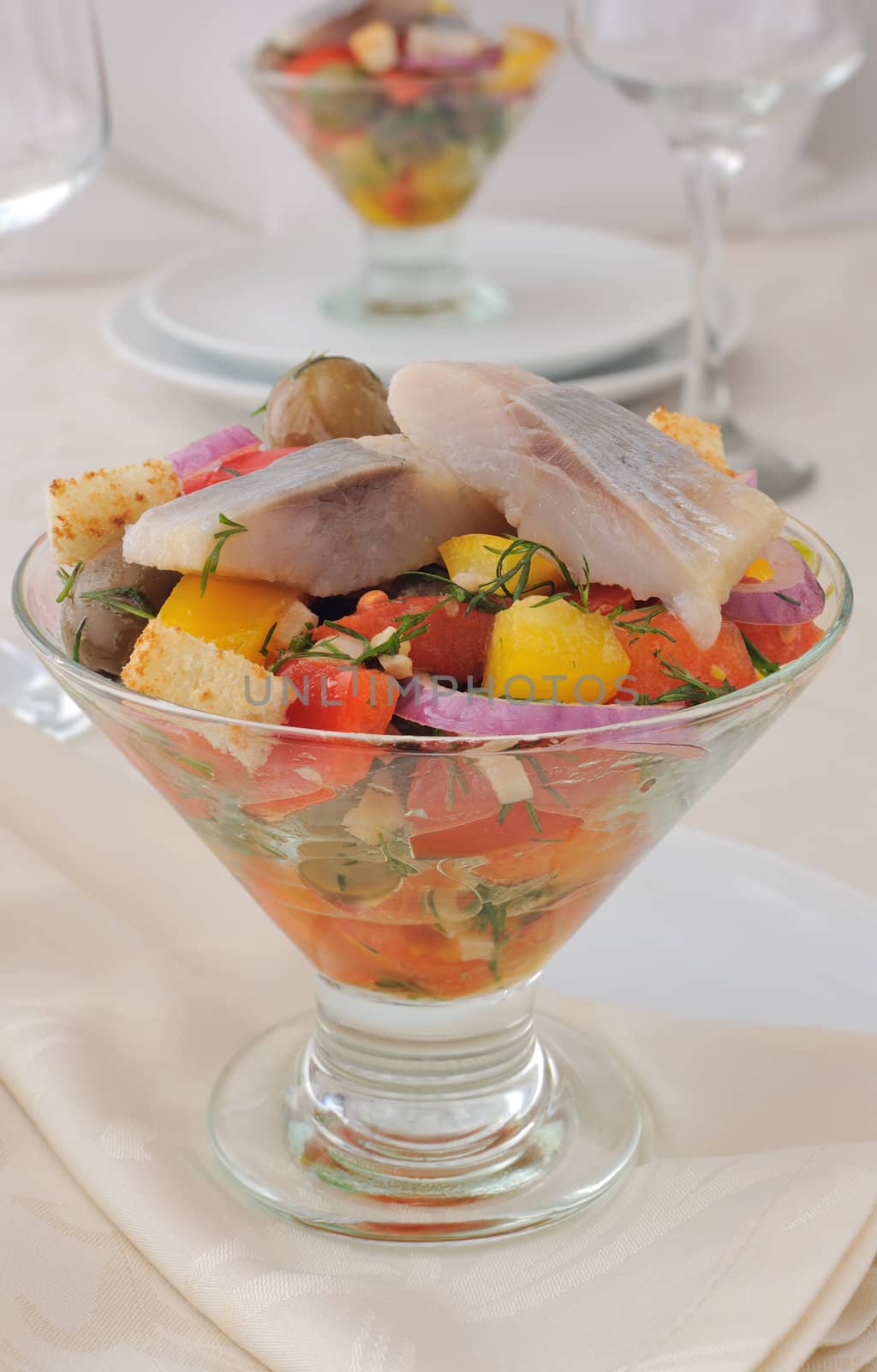 Salad with pieces of herring, white bread with vegetables and herbs