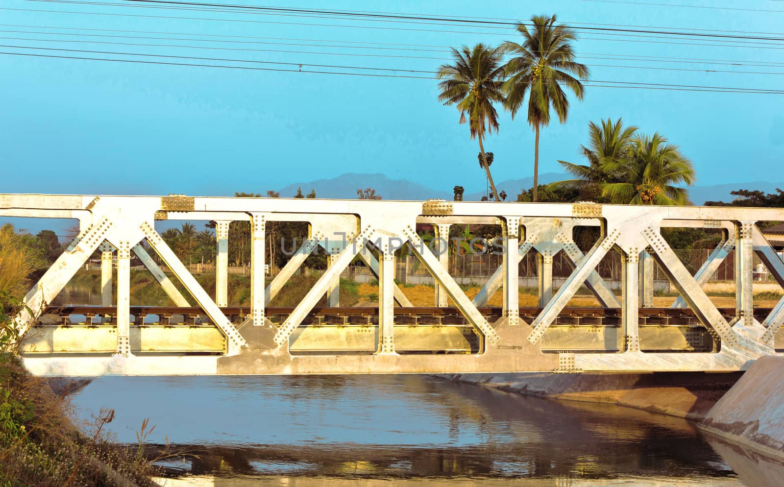 Railway bridge across river in a village outside the city