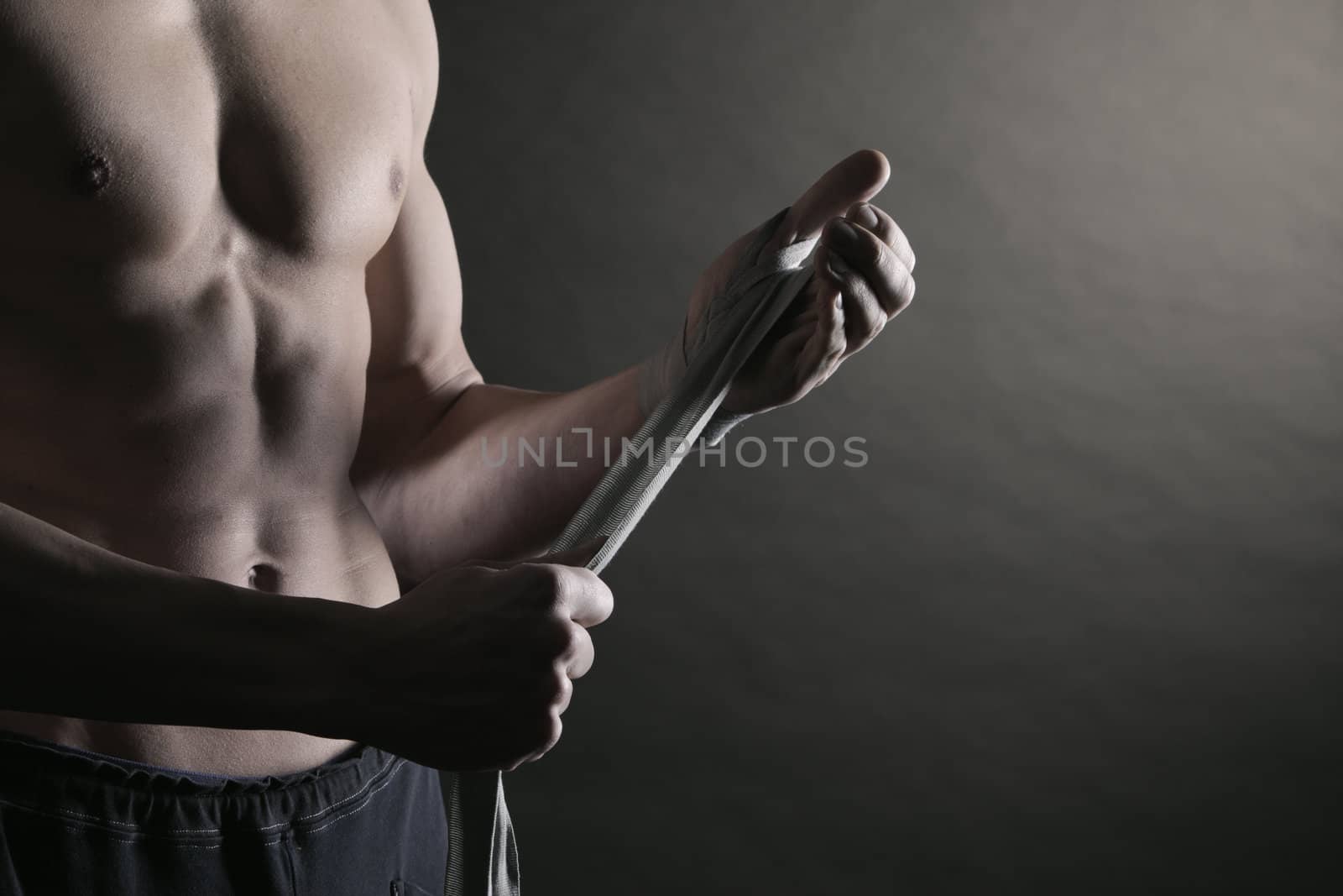 Muscular man boxer wearing white strap on wrist