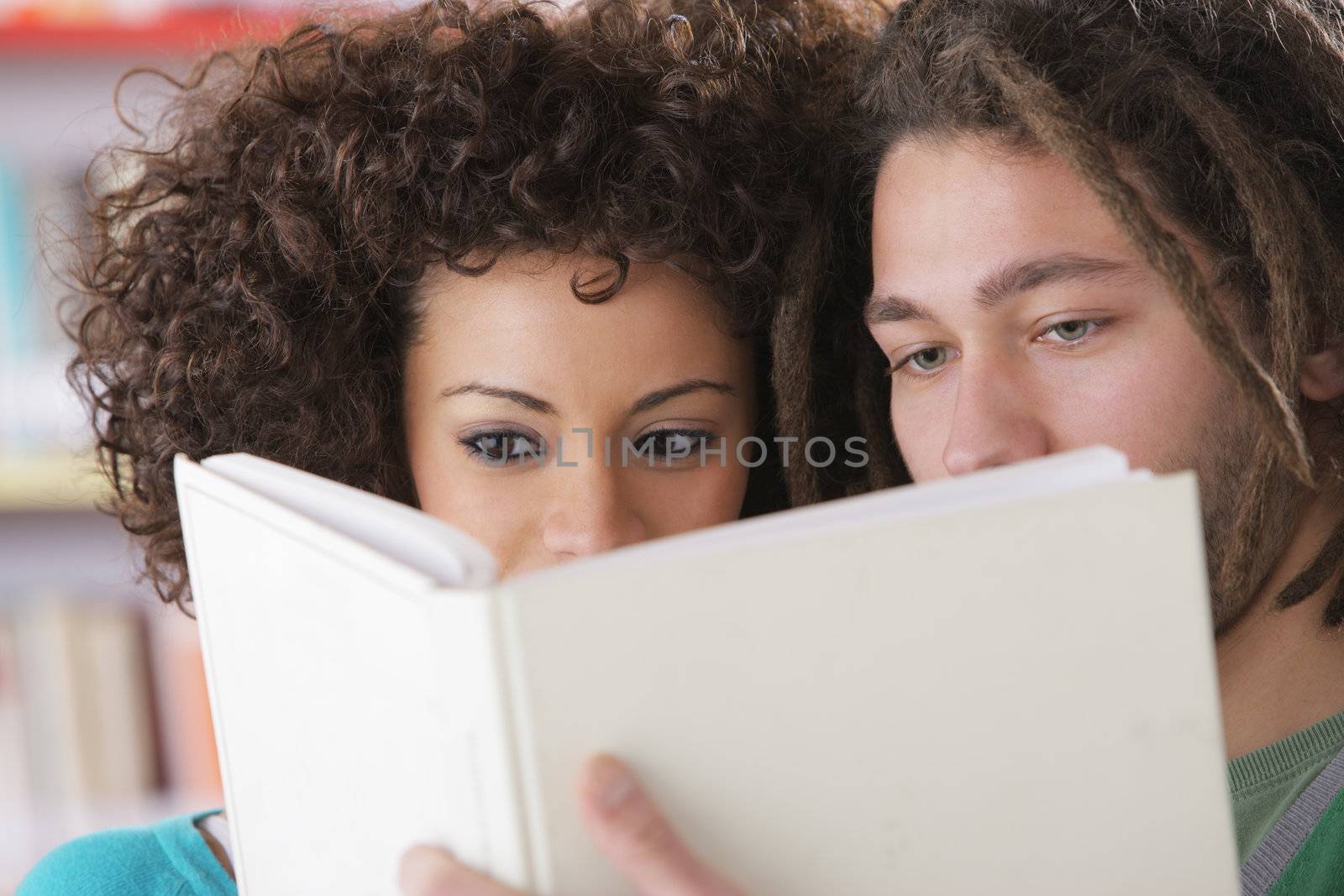 Two students reading a book together