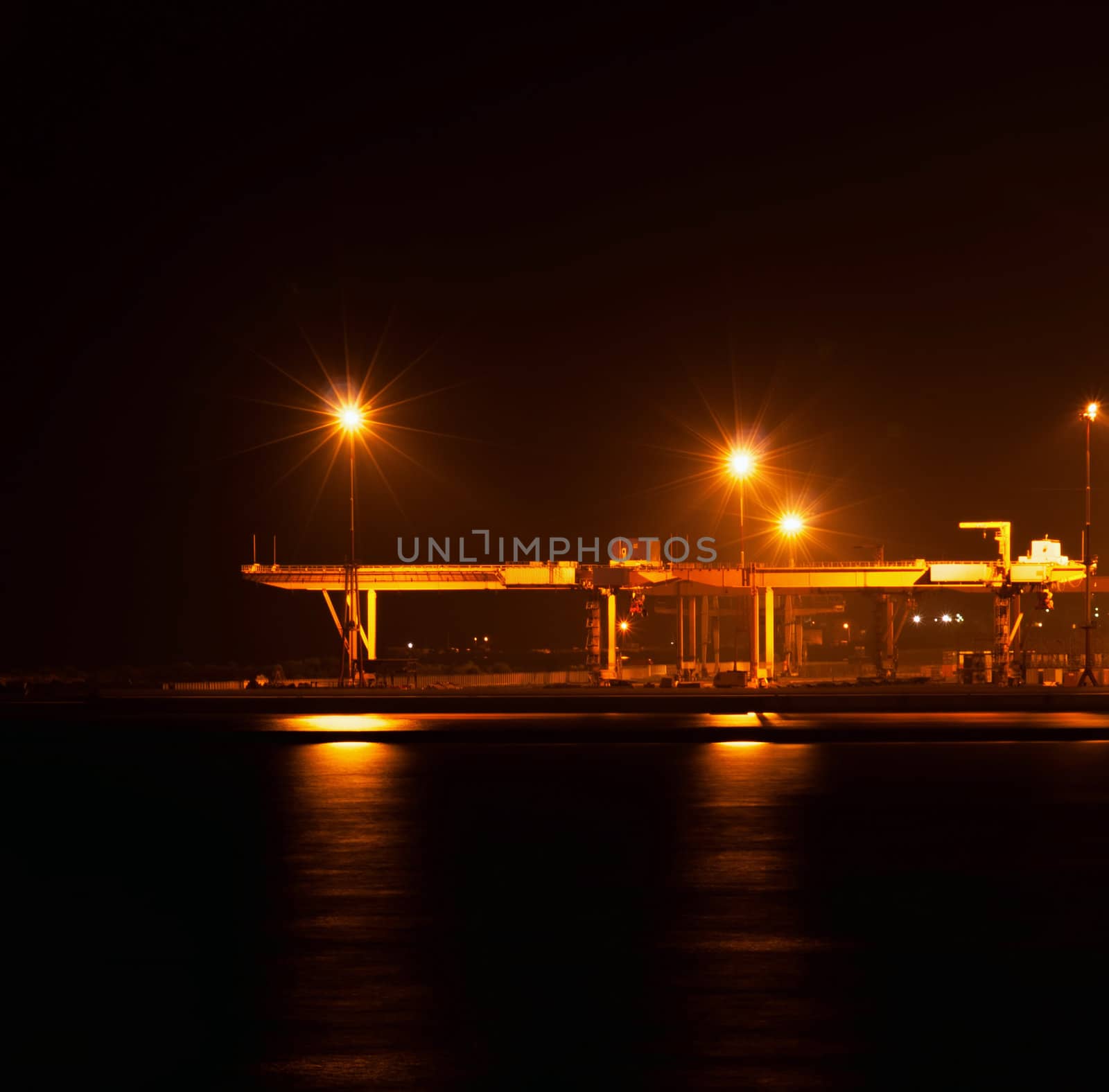 the industrial port at night under floodlights