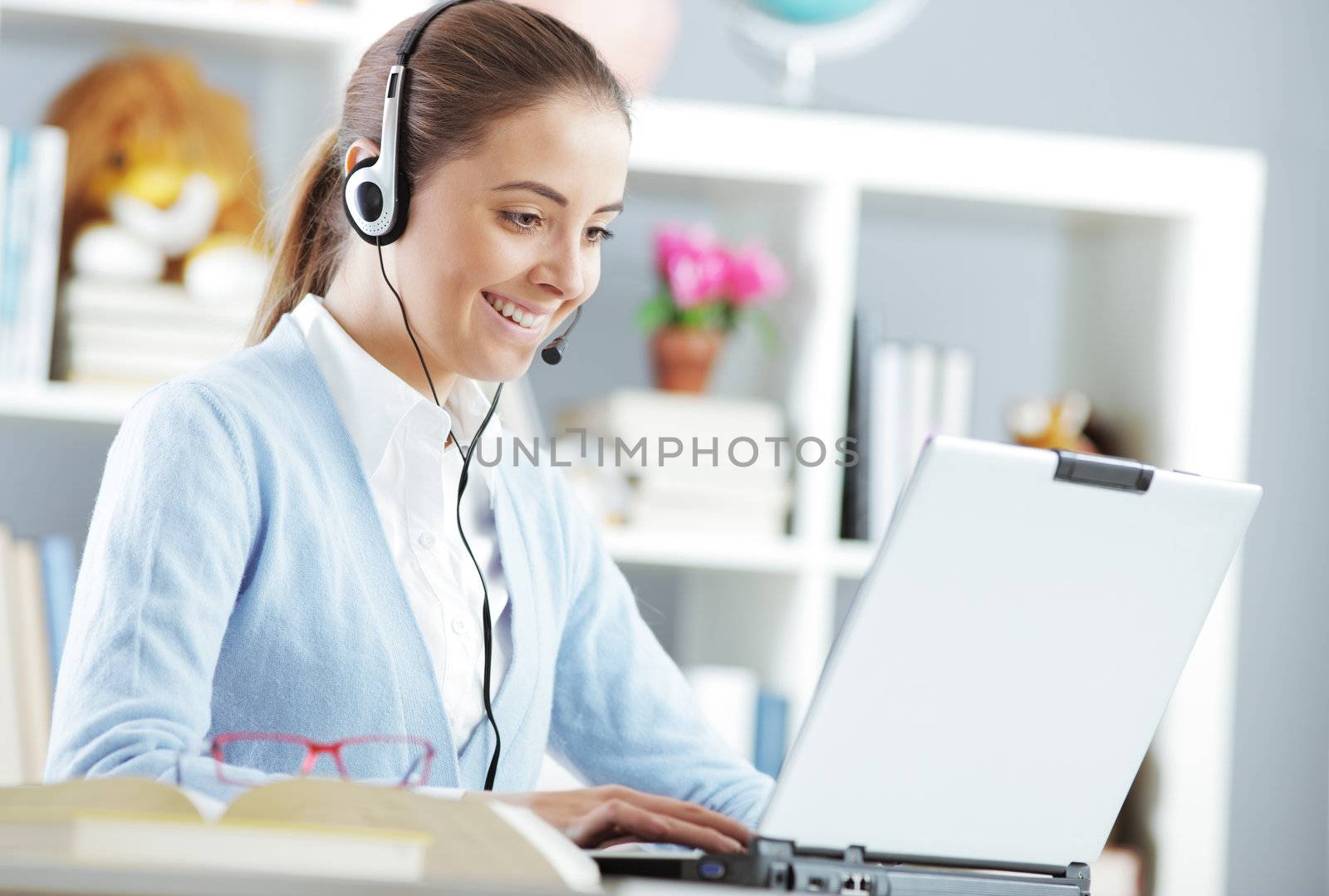 Young girl chating on laptop with headset