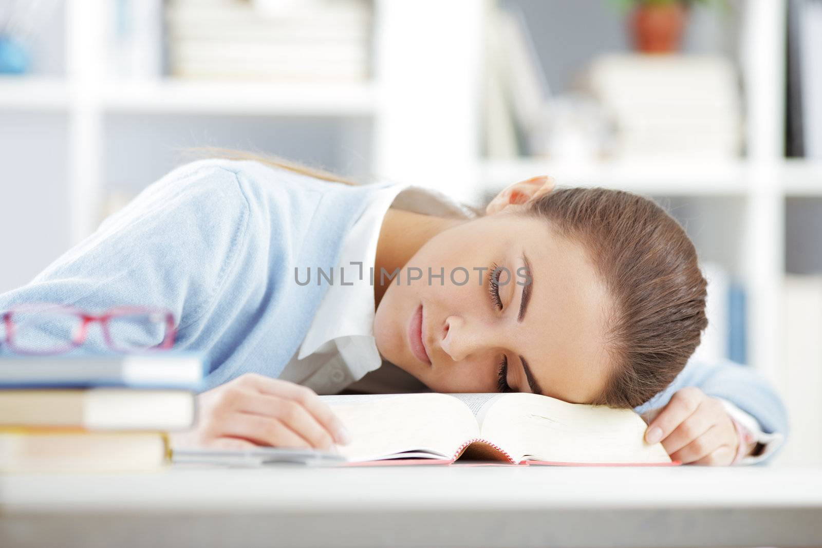 female student sleeping on book