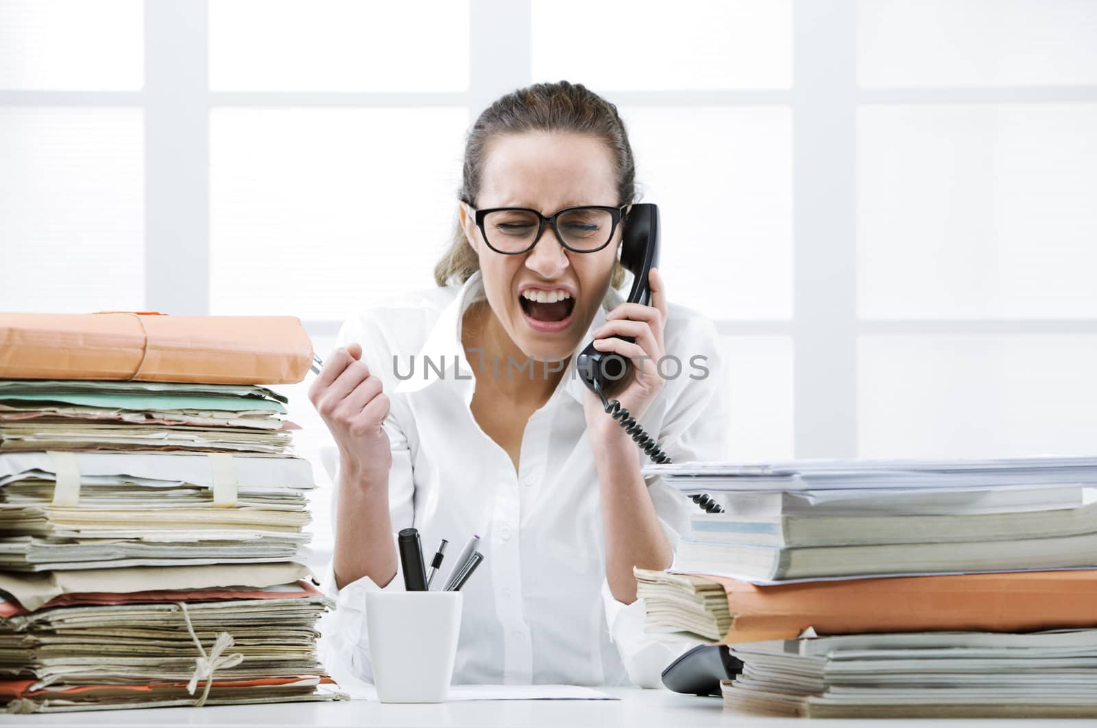 Young business woman shouting to handset phone