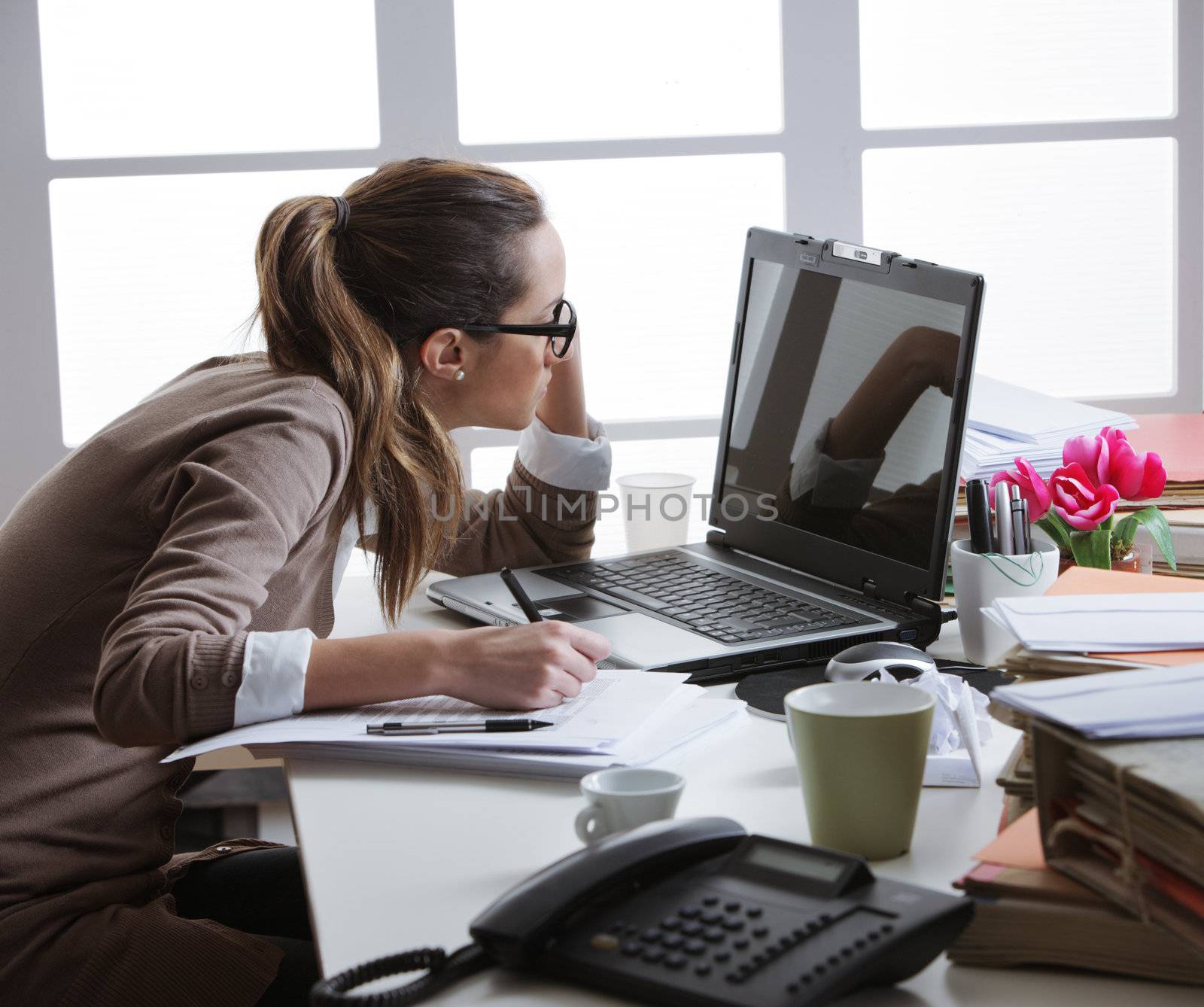 Young tired businesswoman with tons of documents