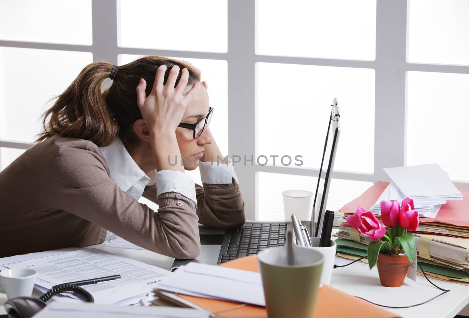 Young and beautiful businesswoman tired from work in the office.Woman holding her head