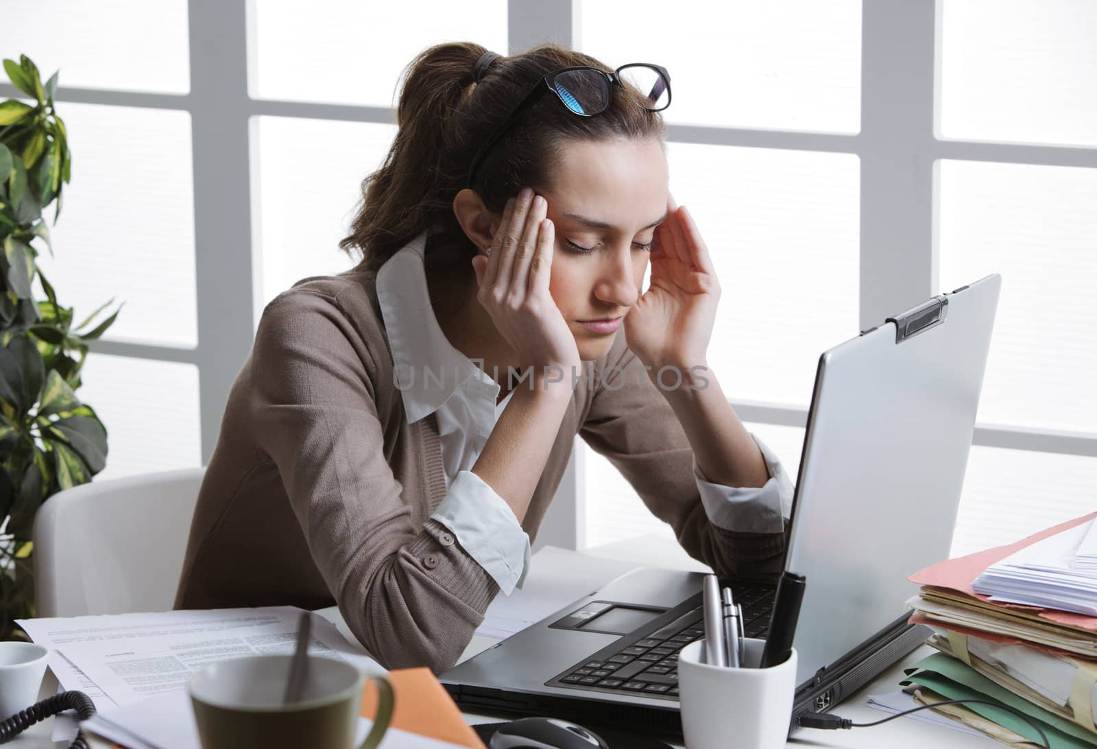 Exhausted businesswoman having a headache.