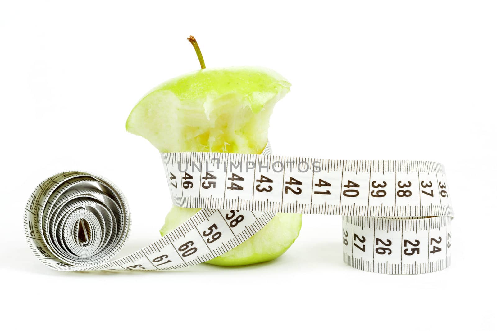 Green bitten apple isolated on white background with measuring tape
