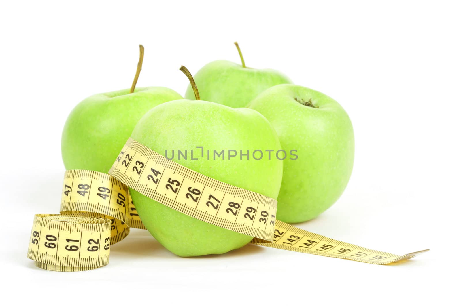 Green apples and yellow measuring tape isolated on white background