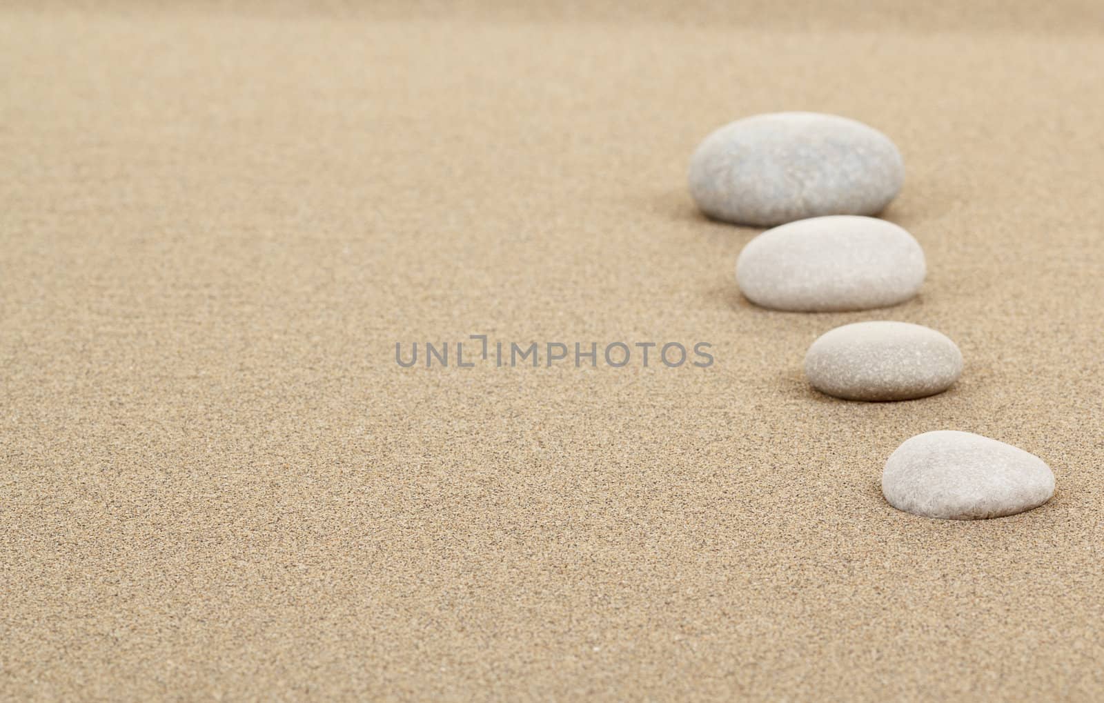 four zen stones in sand as background or backdrop