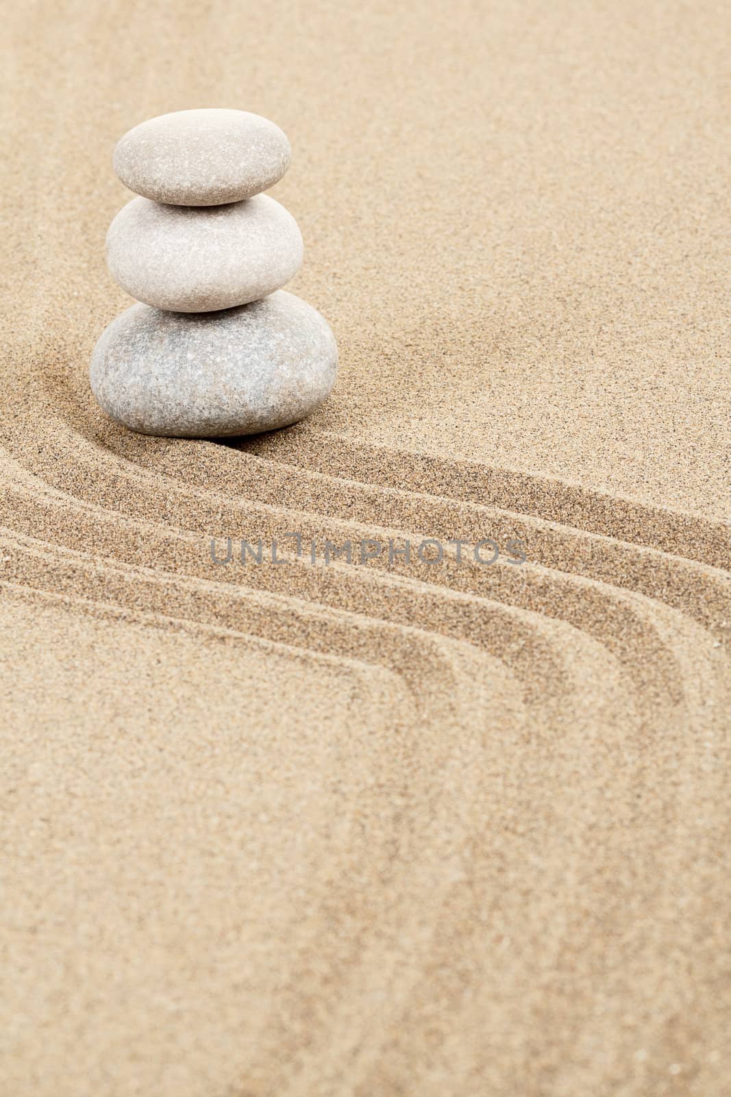 Balance of three zen stones in sand 