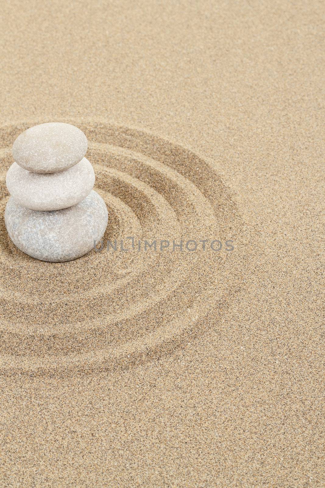 balance zen stones in soft sand with circles