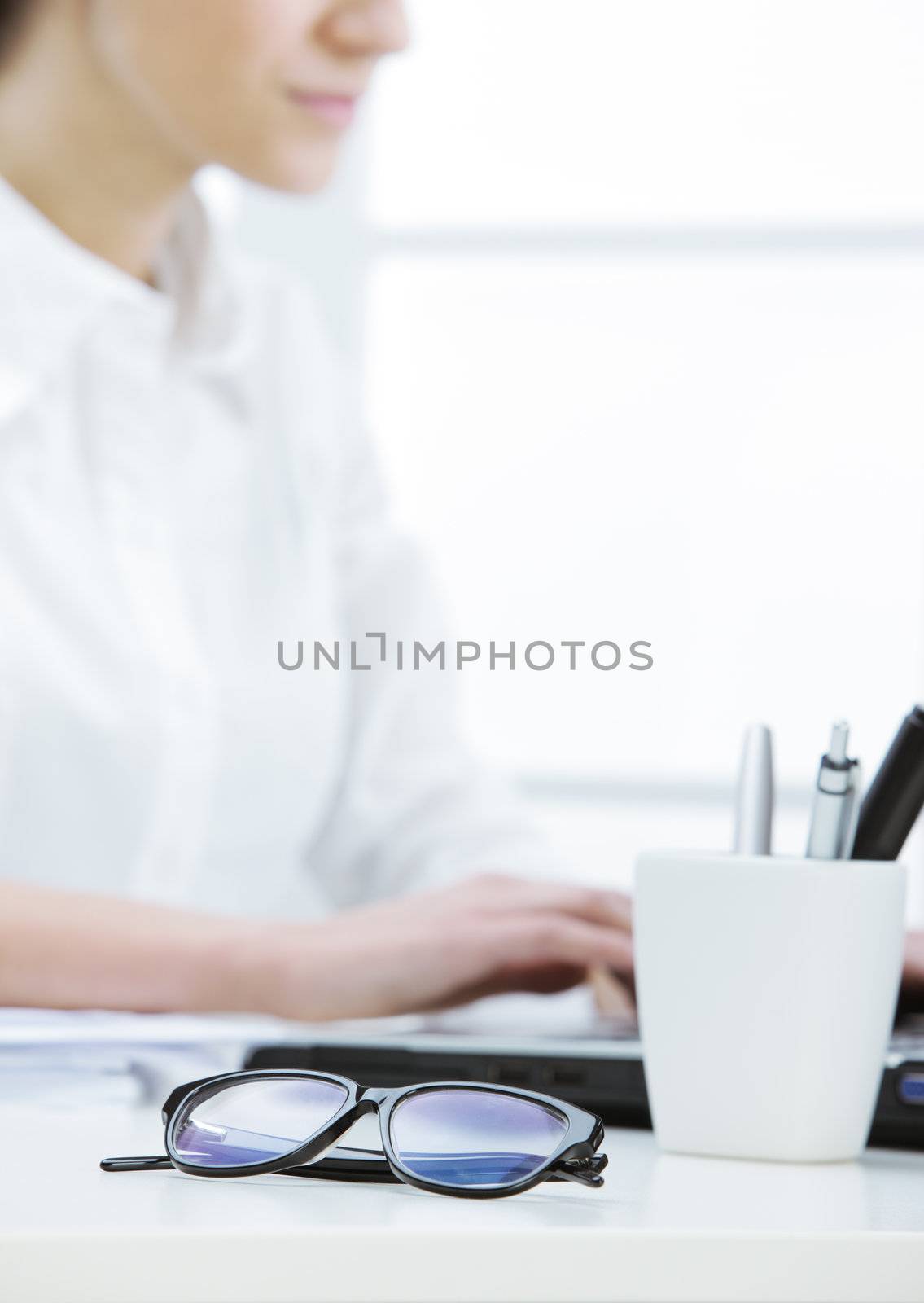 glasses in the foreground and female secretary