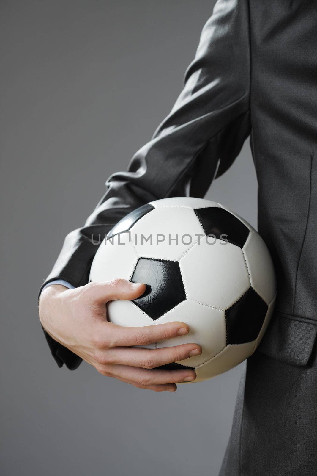Elegant businessman holding a soccer ball by stokkete