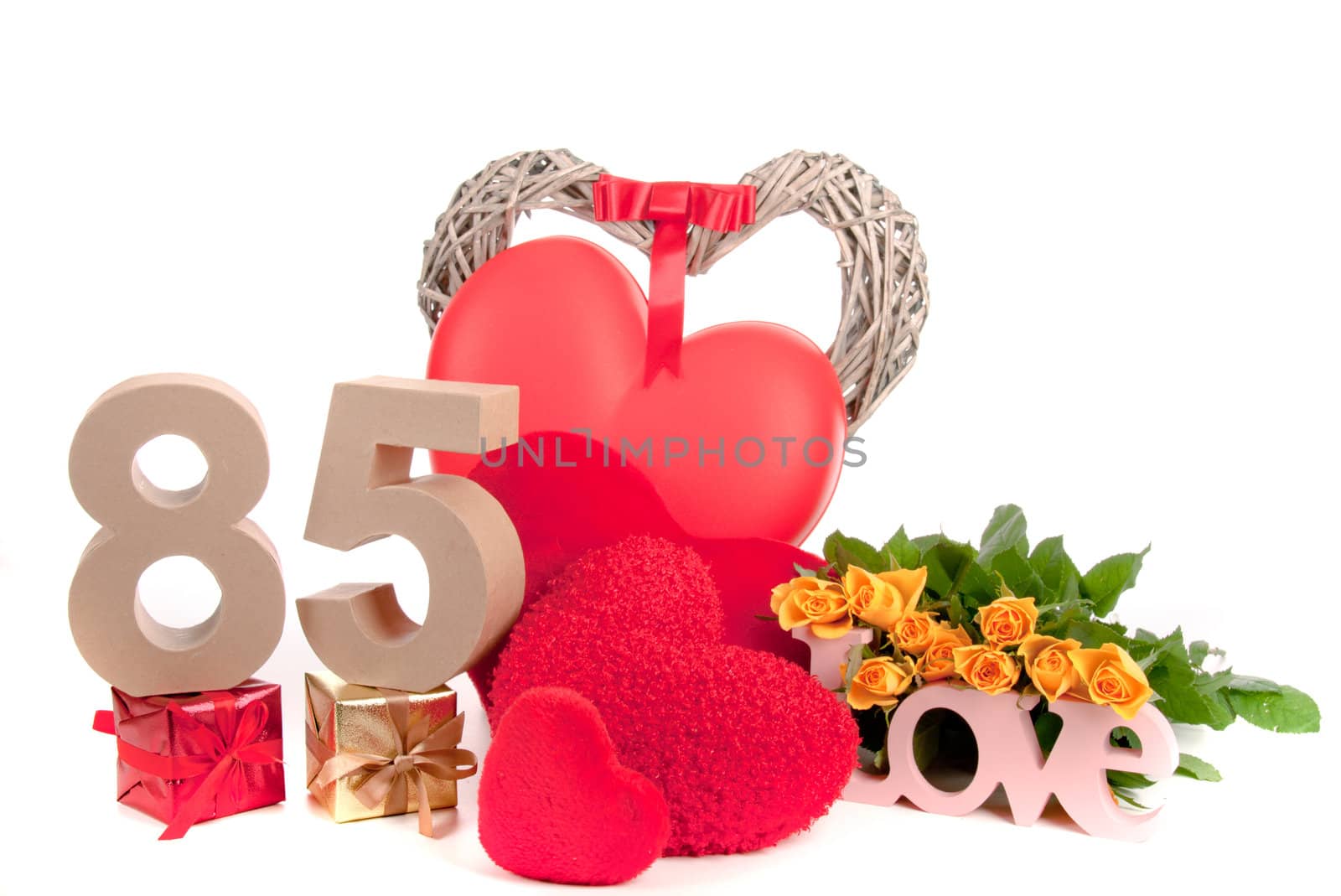 Number of age in a colorful studio setting with heart and gifts and yellow roses