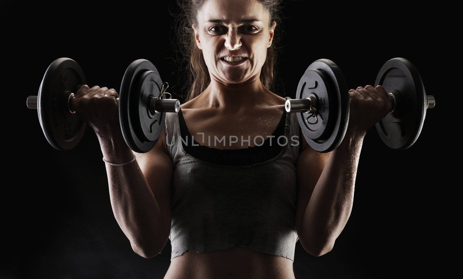 Young woman lifting the dumbbells