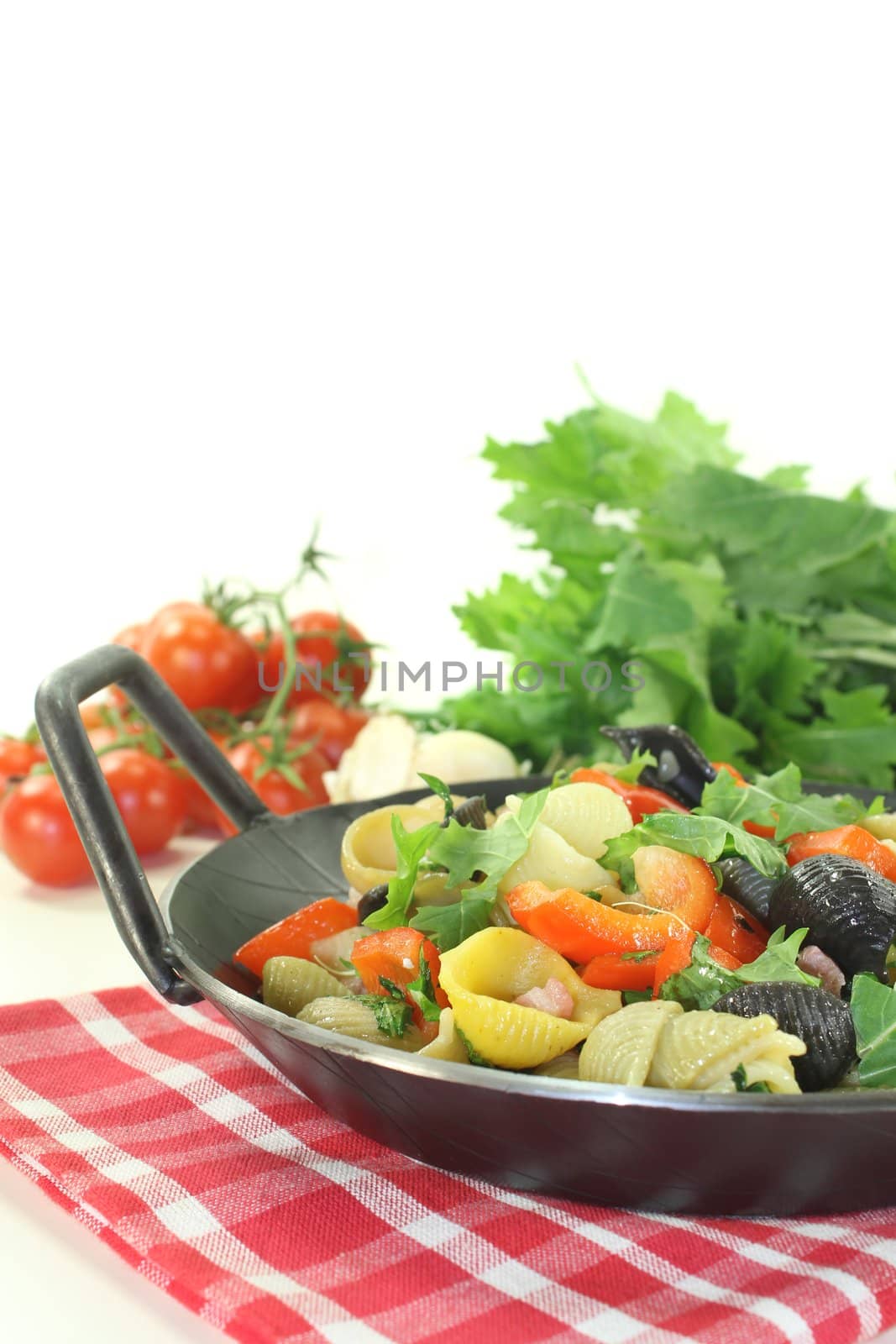 freshly cooked Pasta pan with bell pepper, turnip greens, ham strips, tomatoes and garlic