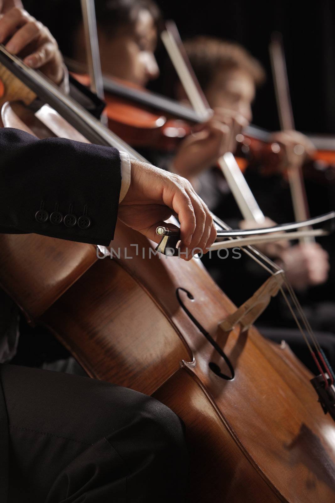 Symphony concert, a man playing the cello, hand close up by stokkete