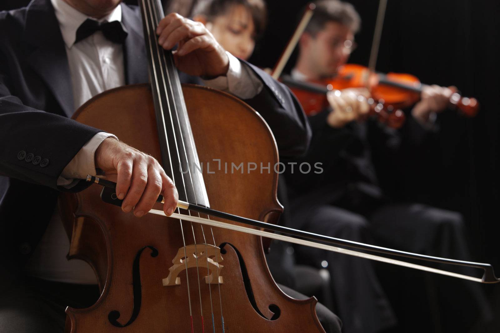 Symphony concert, a man playing the cello, hand close up