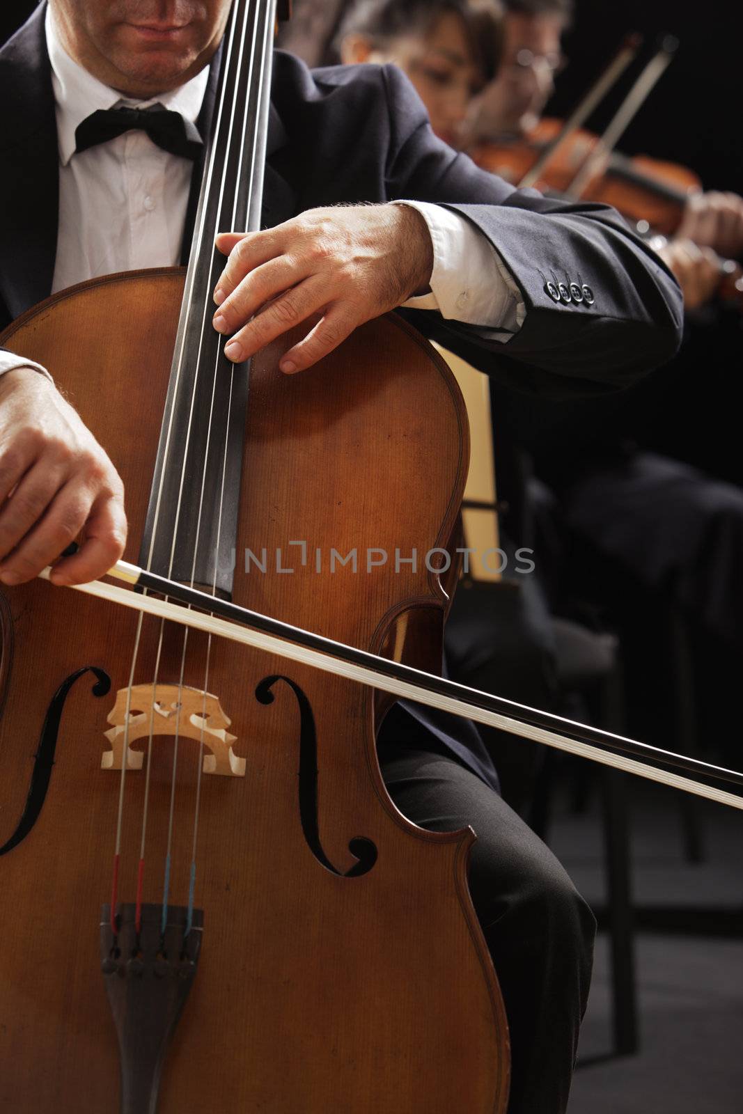 Symphony concert, a man playing the cello, hand close up