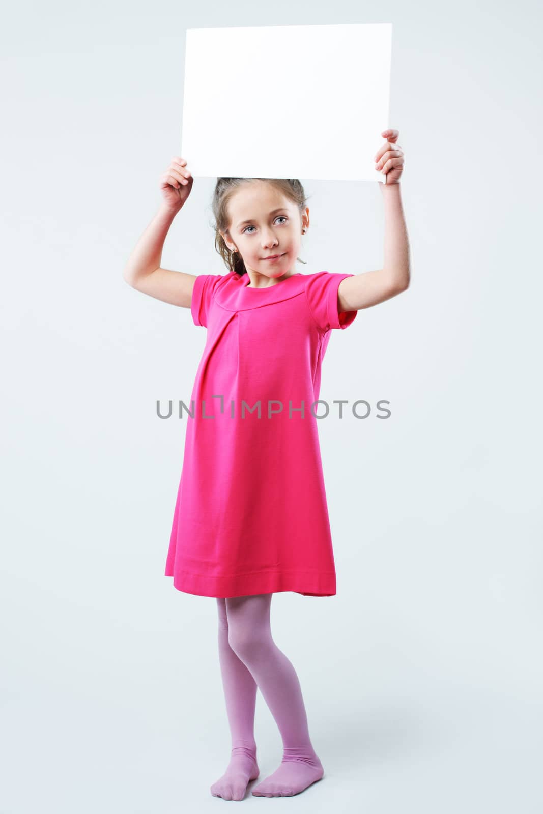 A little girl holds a blank sign, ready for your text