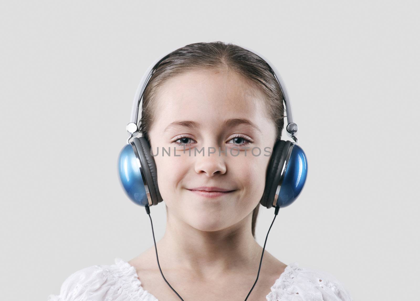 little pretty child listening music in headphones