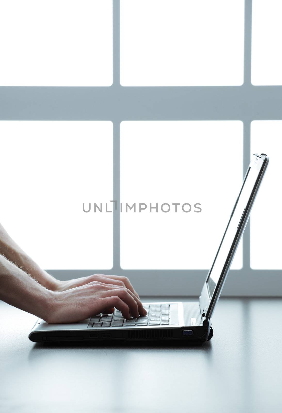 Human hands typing on a laptop