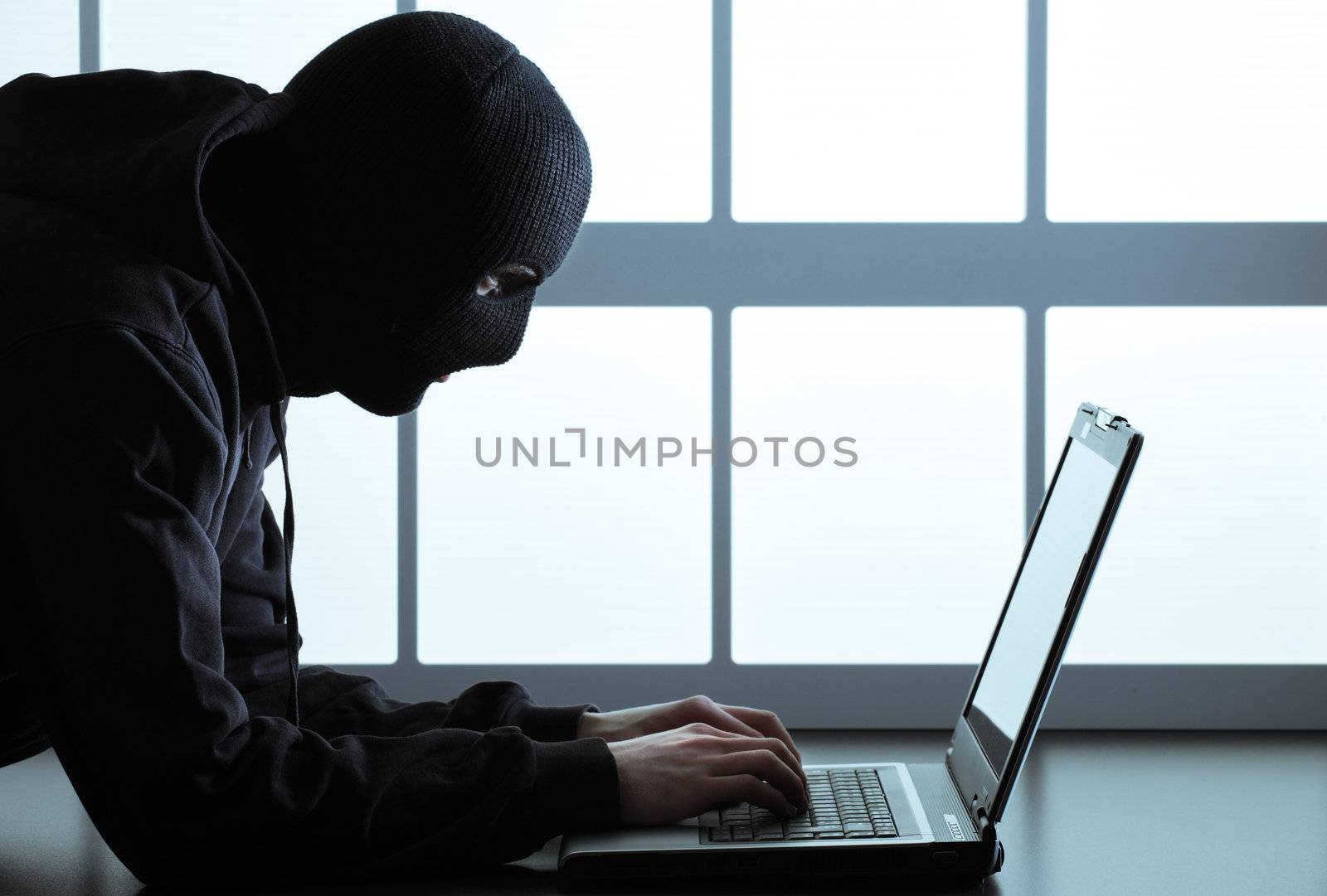 Computer hacker - Male thief stealing data from laptop