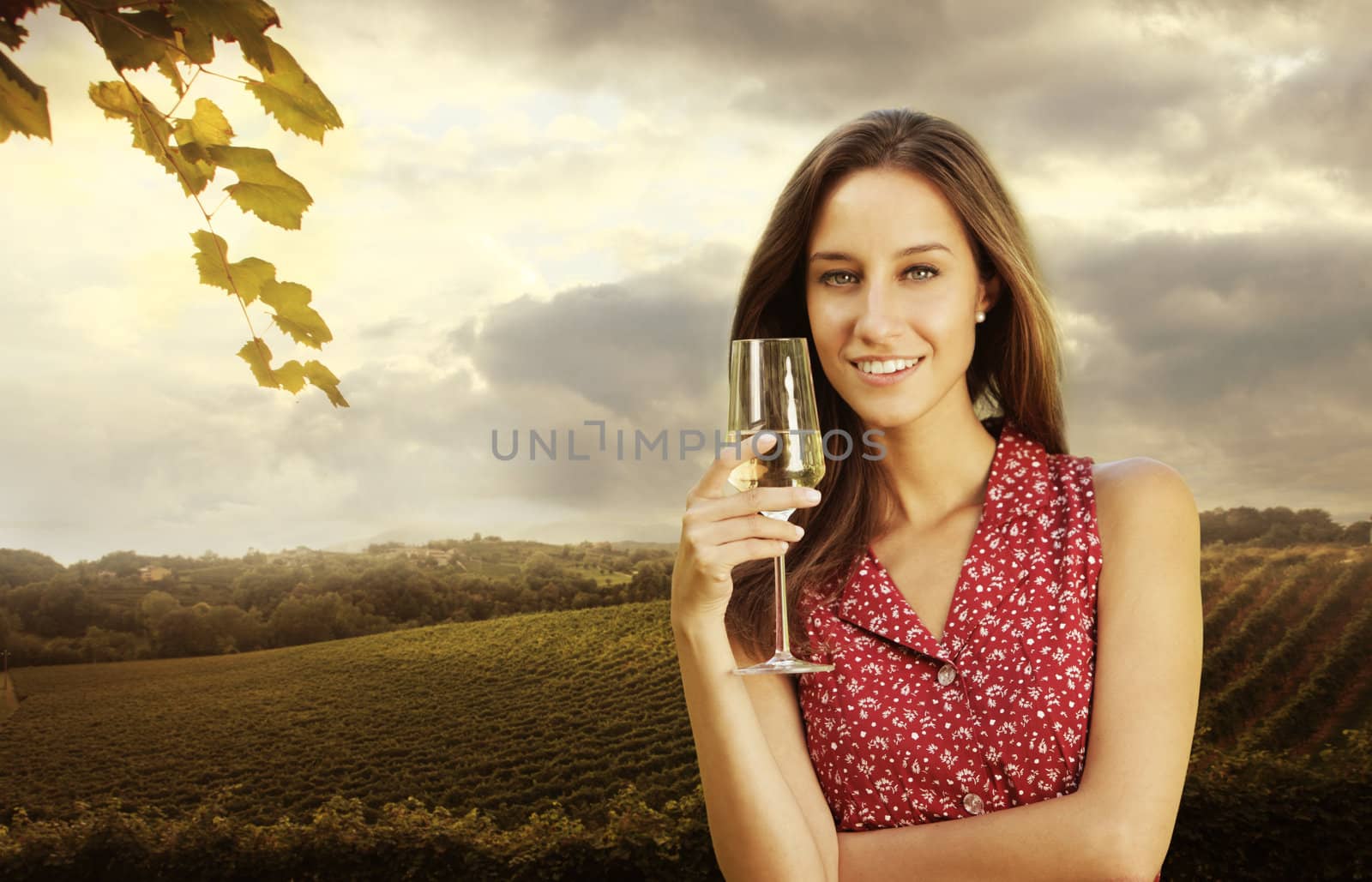 Beautiful woman in vineyard with a glass of champagne