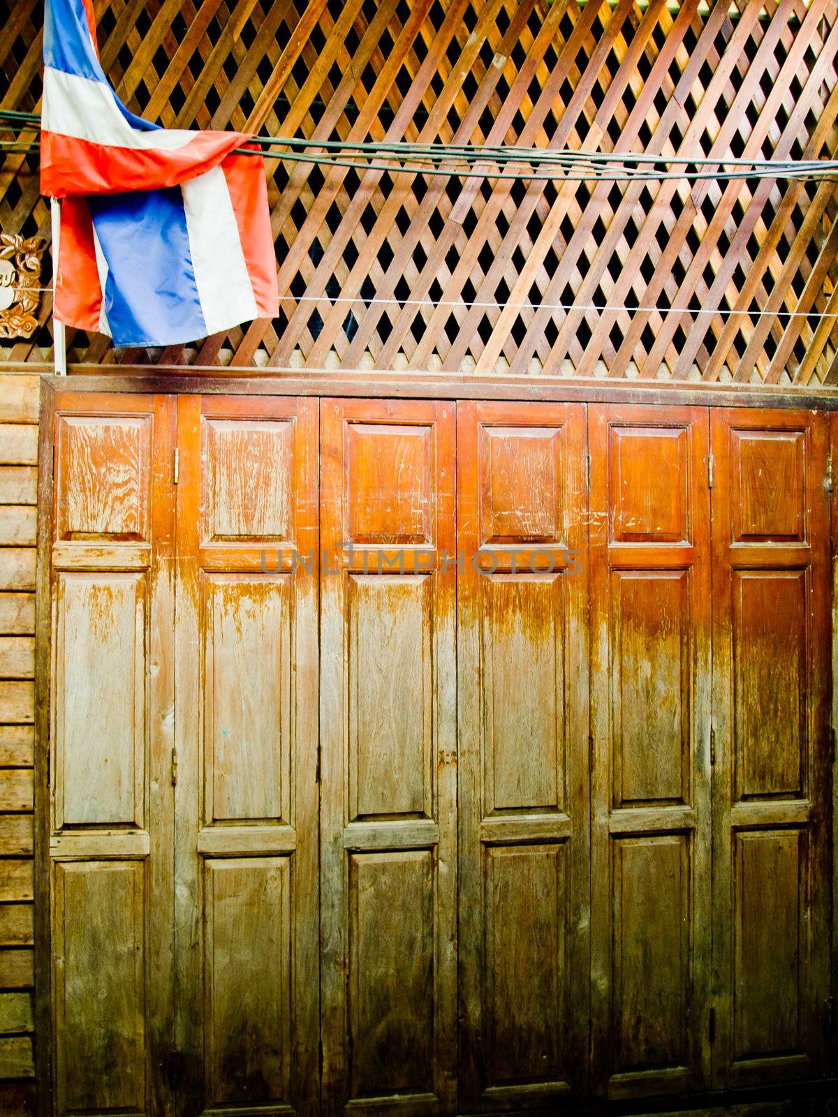 Old wood door with Thailand flag by gjeerawut