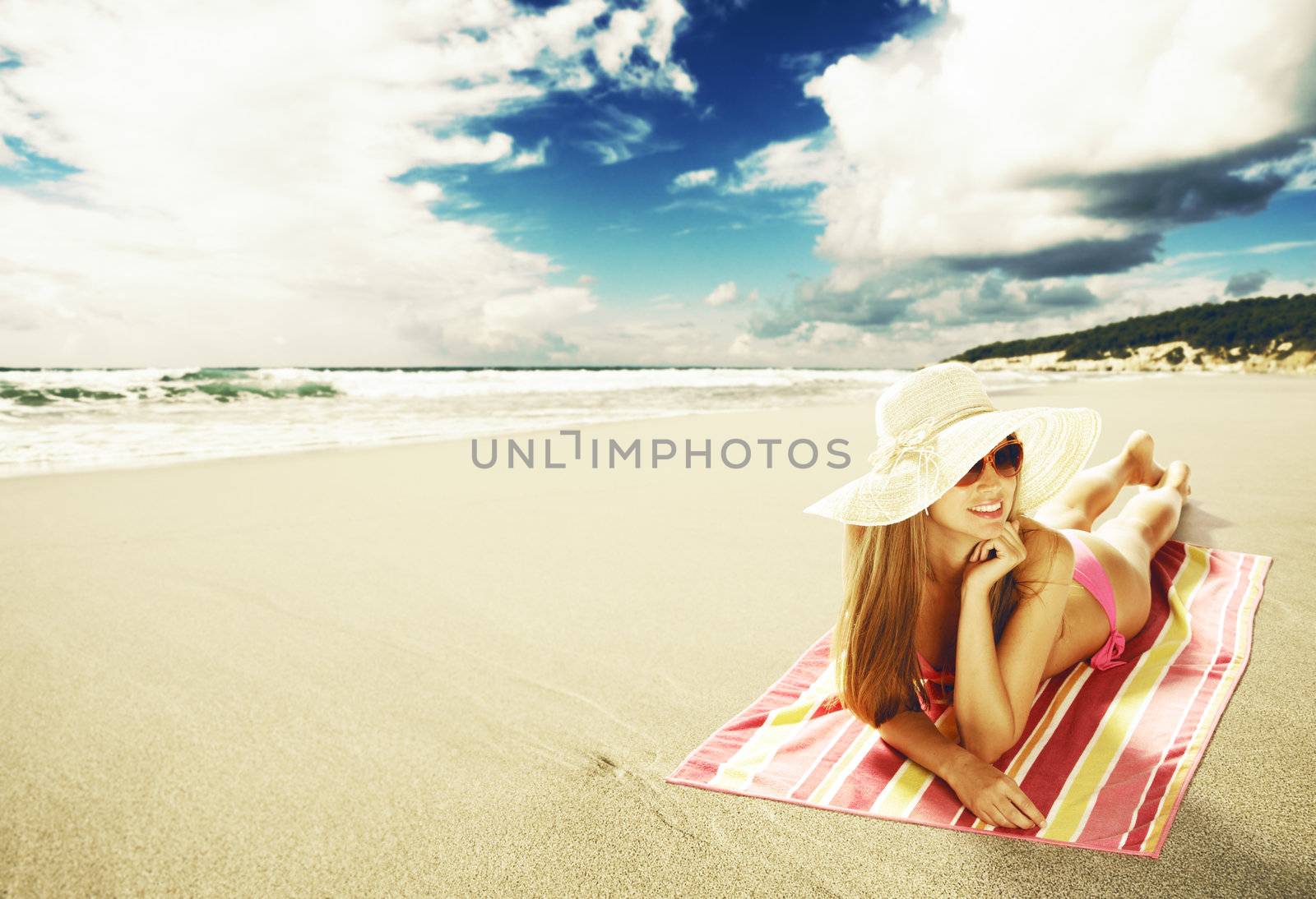 Sexy young woman lying down on the beach