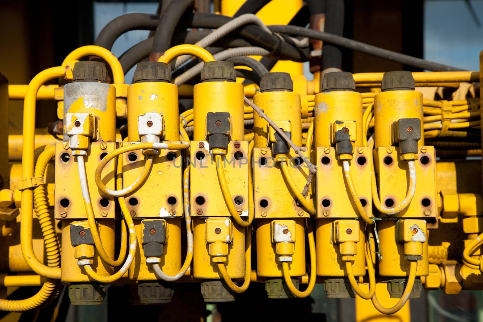 A unit with yellow plastic power connectors with wires and hoses.
