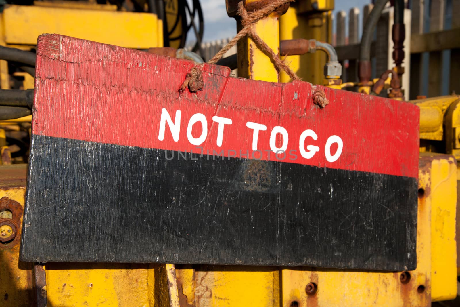 A wooden sign painted red and black with the words 'NOT TO GO' painted in white.