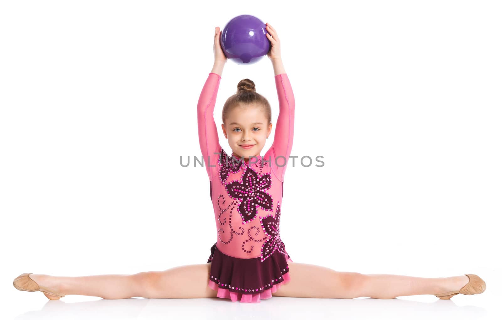 Young cute girl doing gymnastics with ball over white background