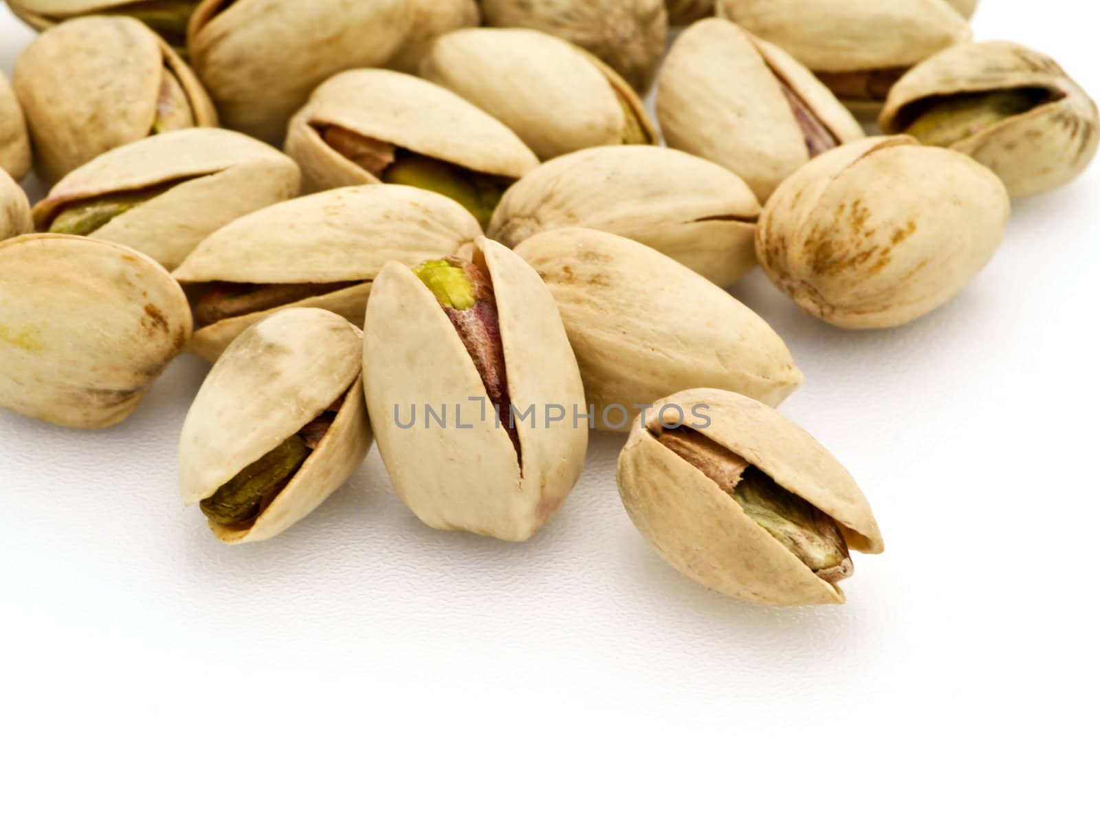 pistachios heap against white background by Noppharat_th