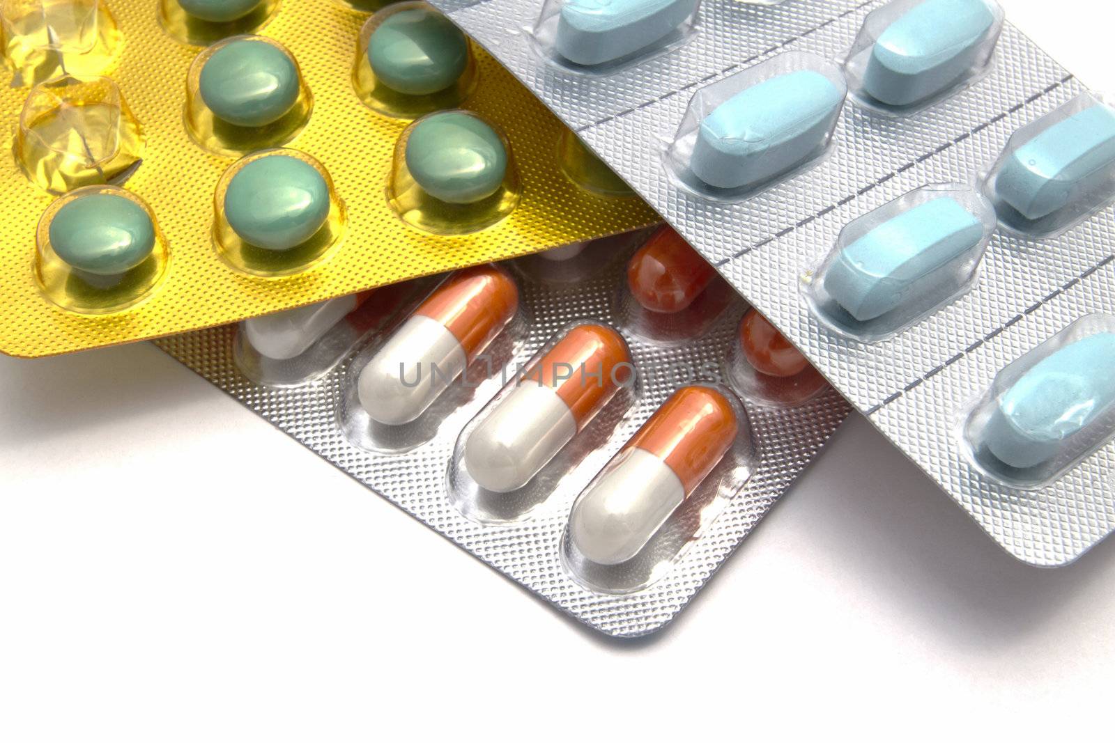 Colorful pills and capsules closeup on white background 
