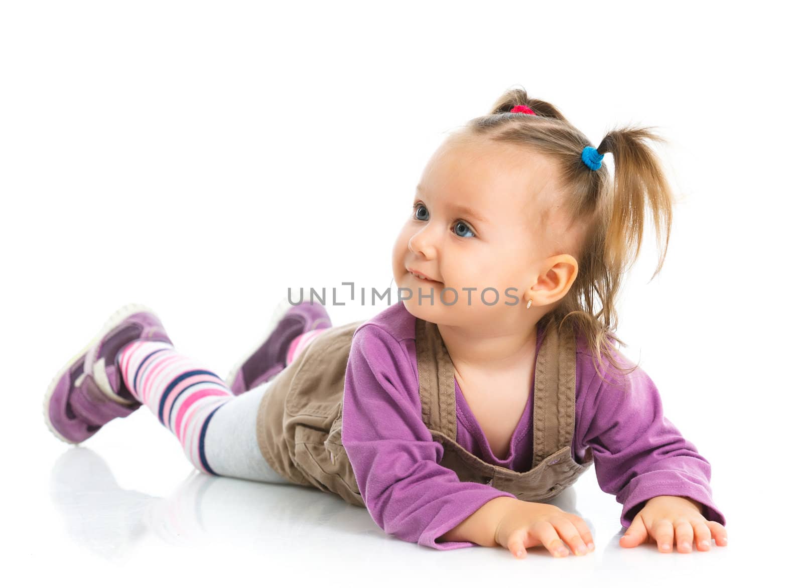 Pretty little girl lying on white background in studio