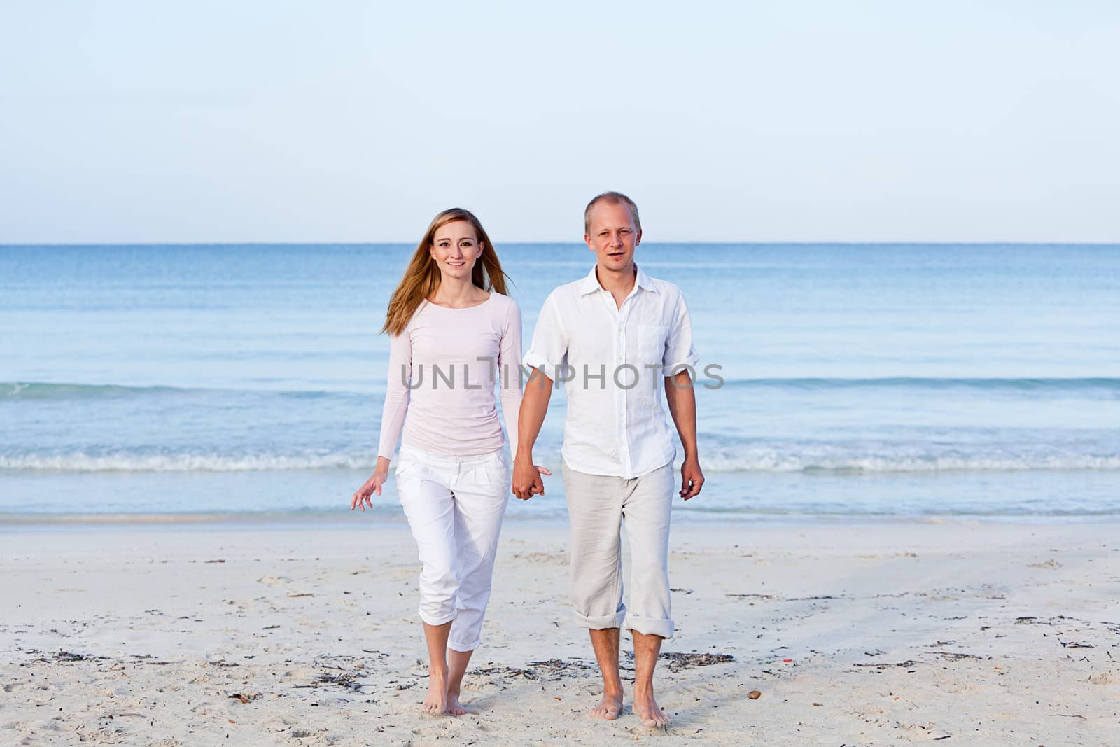 happy young couple in love having fun on the beach blue sky and sunshine 