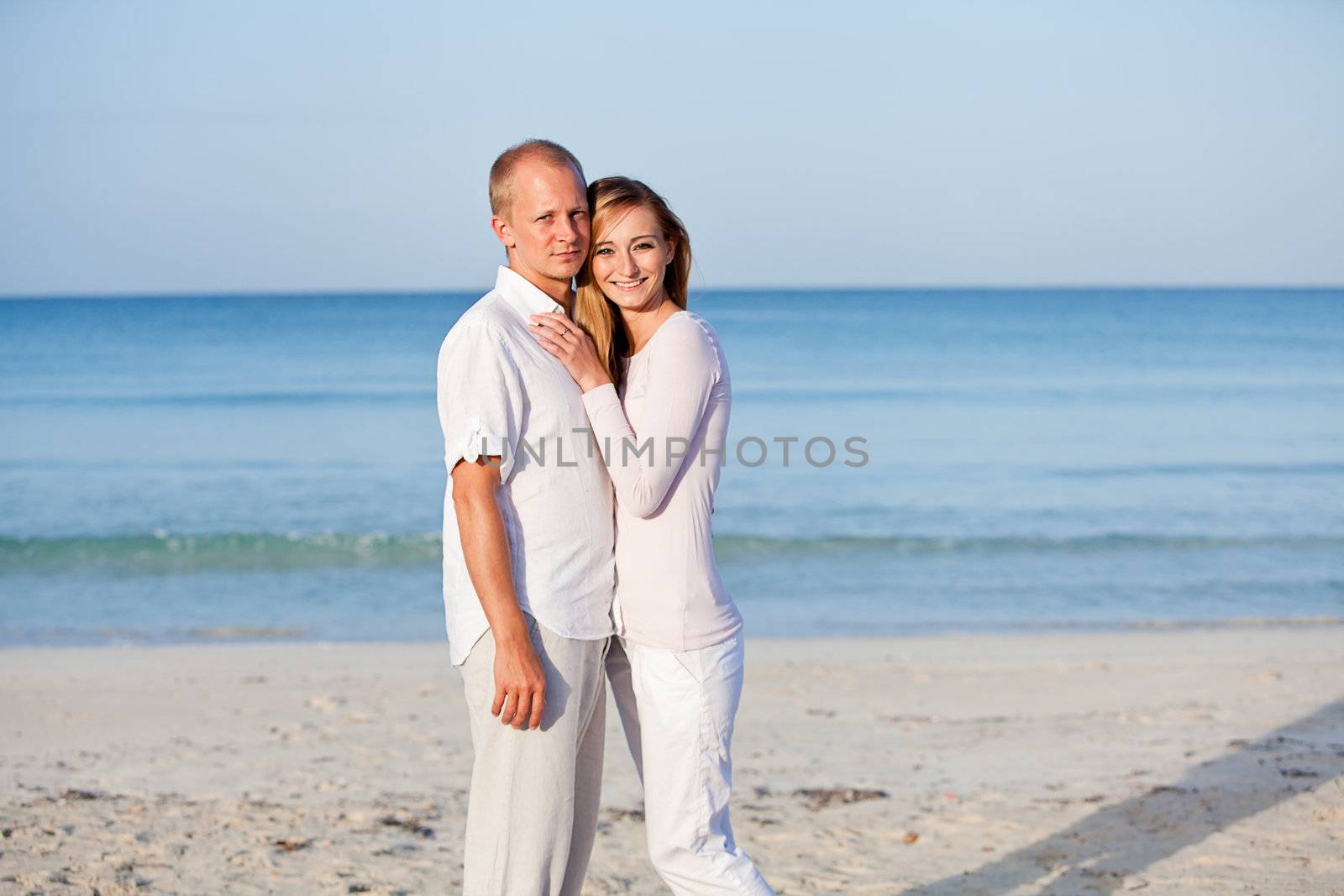 happy young couple in love having fun on the beach blue sky and sunshine 