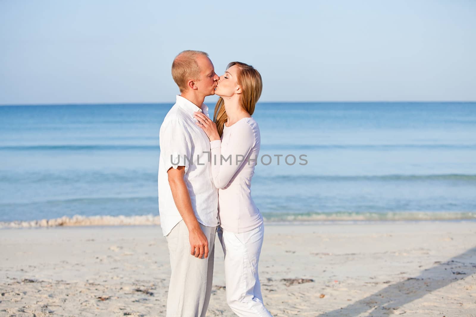 happy young couple in love having fun on the beach blue sky and sunshine 