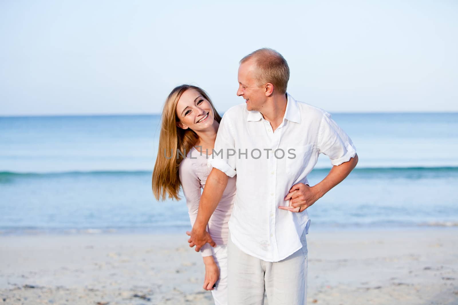 happy young couple in love having fun on the beach blue sky and sunshine 