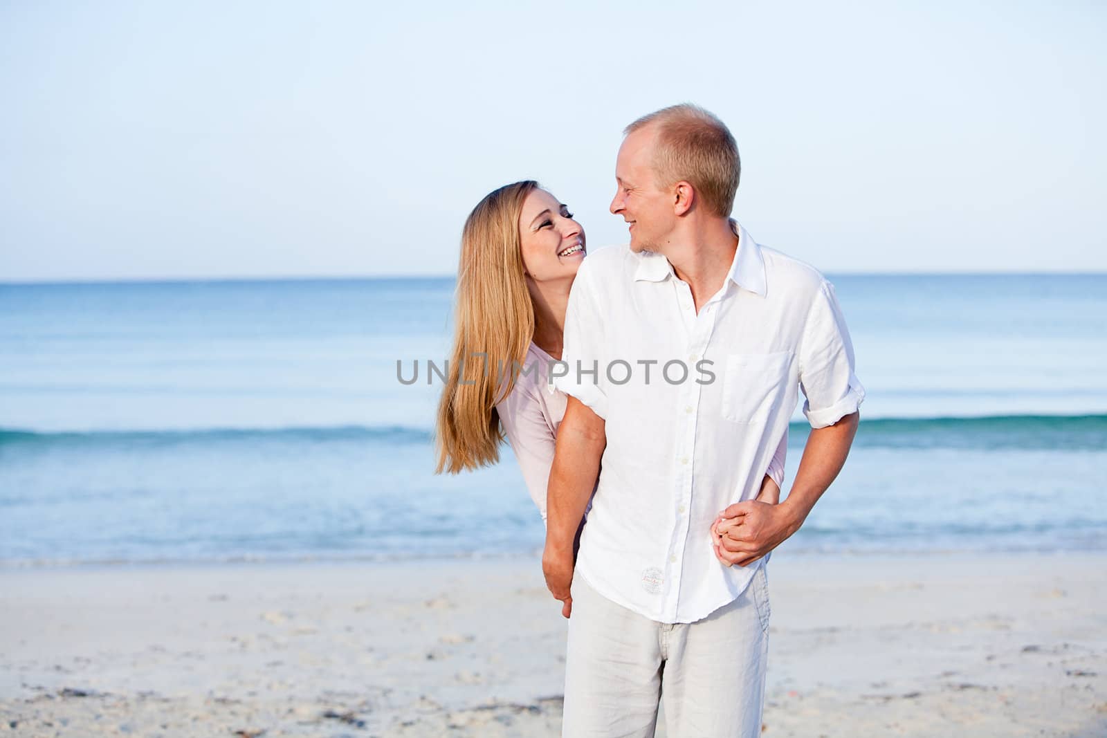 happy young couple in love having fun on the beach blue sky and sunshine 