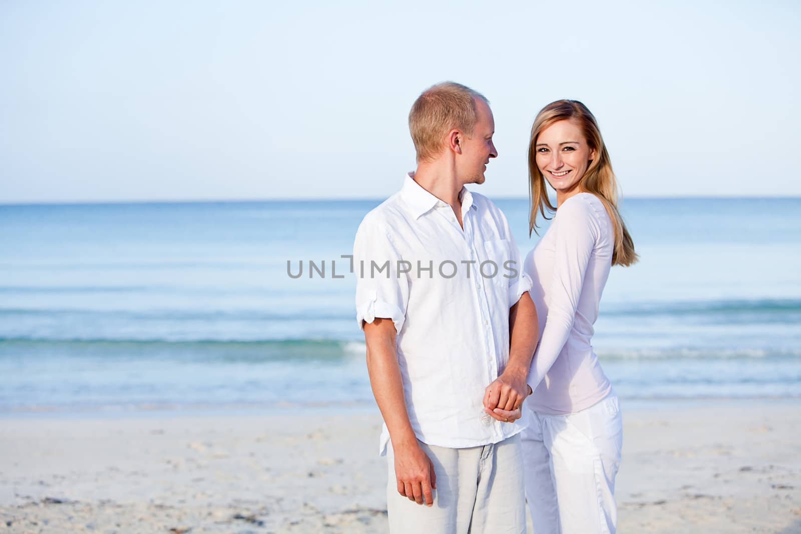 happy young couple in love having fun on the beach blue sky and sunshine 