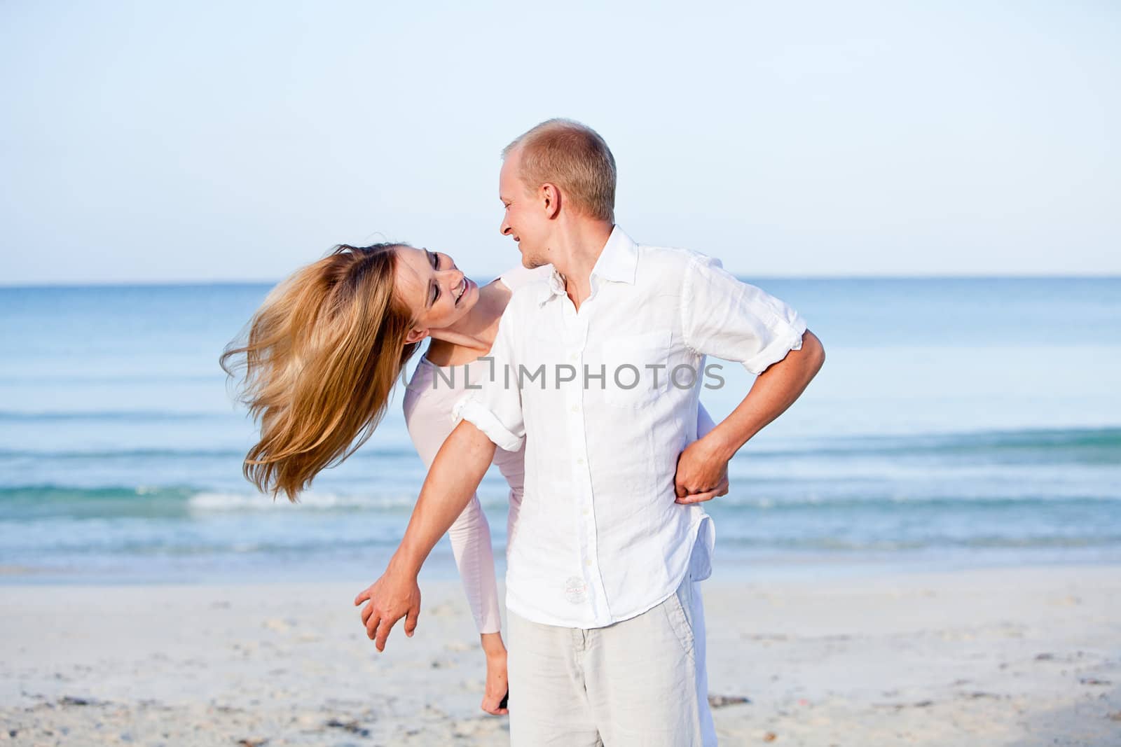 happy young couple in love having fun on the beach blue sky and sunshine 