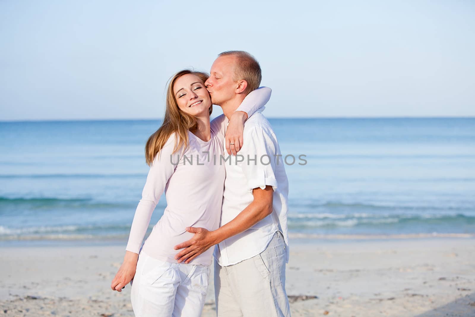 happy young couple in love having fun on the beach blue sky and sunshine 